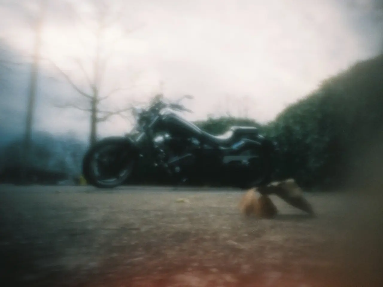 Motorbike is on the road. Background there are trees.