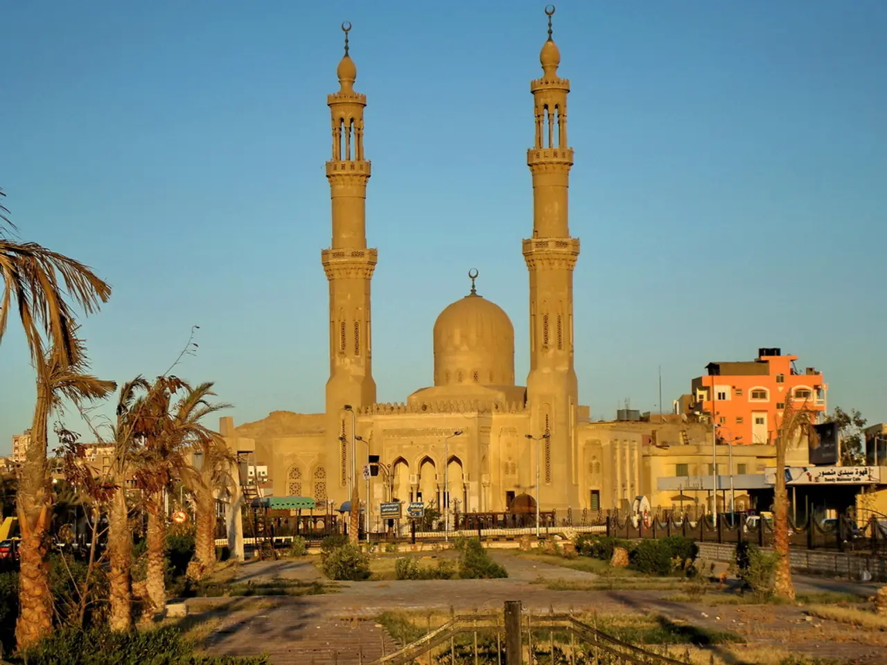 In this image in the center there is one mosque, and in the background there are some buildings. On...