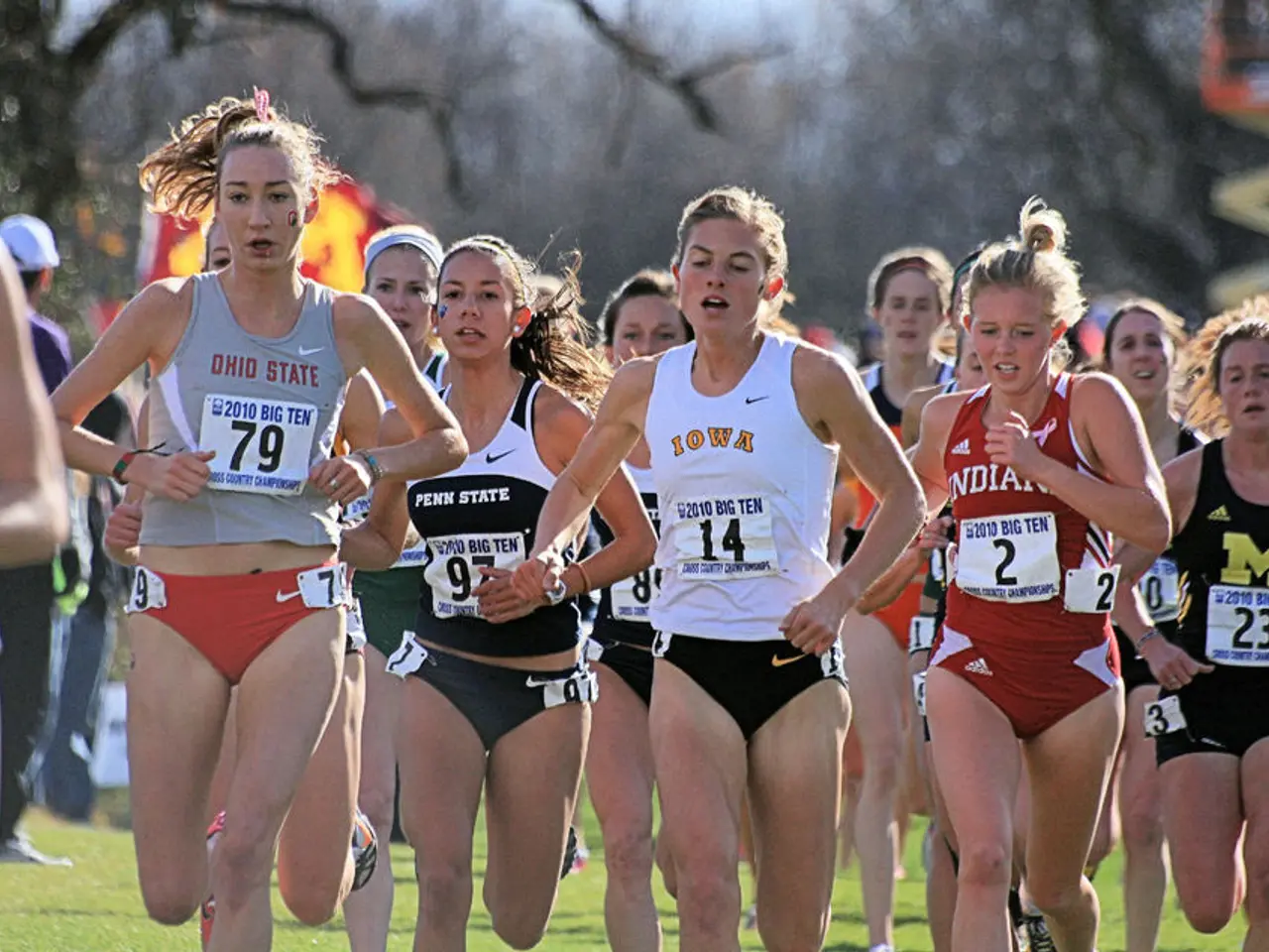 In this image there are group of girls running on the ground. All the girls are wearing the badge...