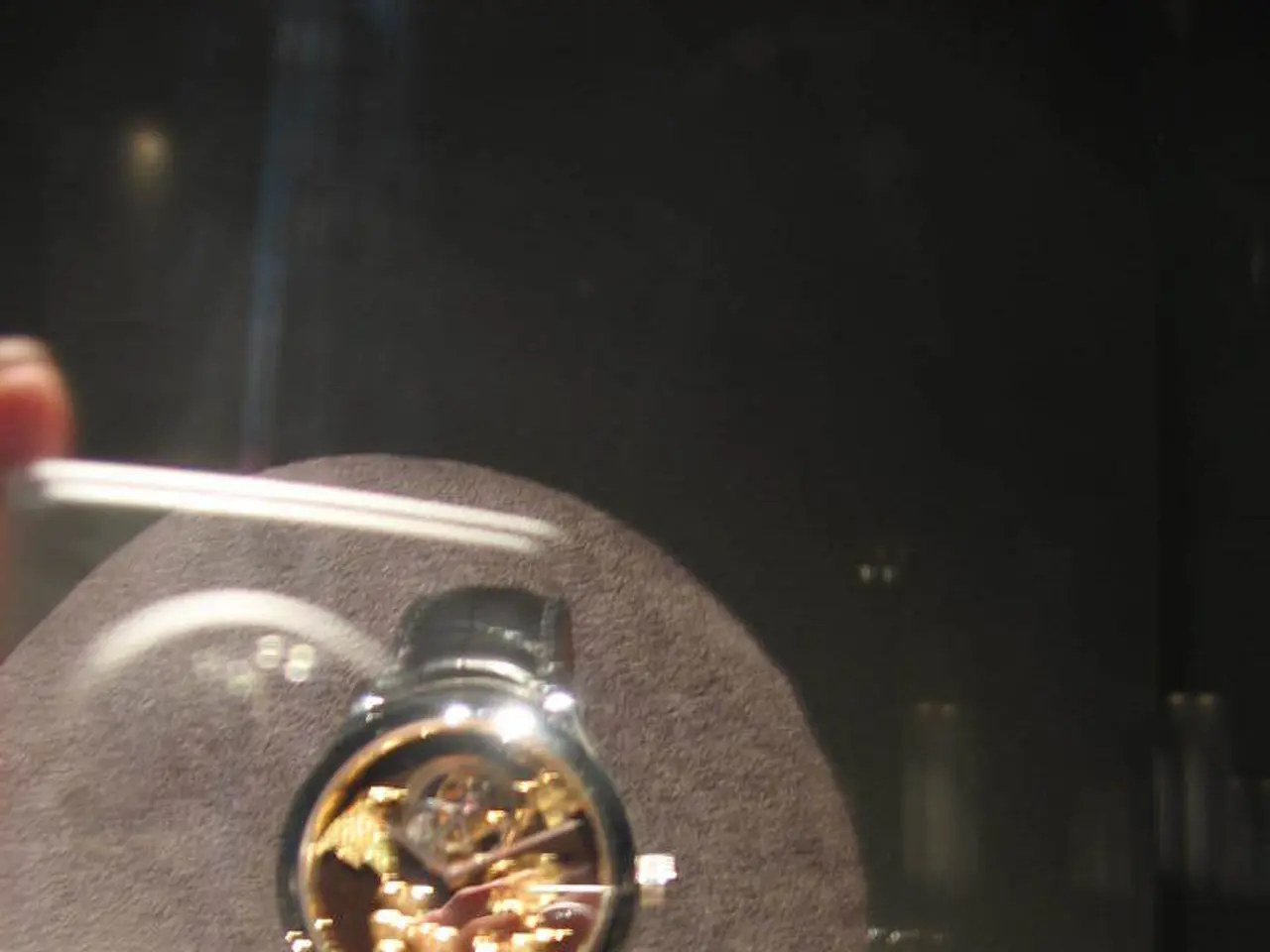 In this image we can see a watch to the stand.