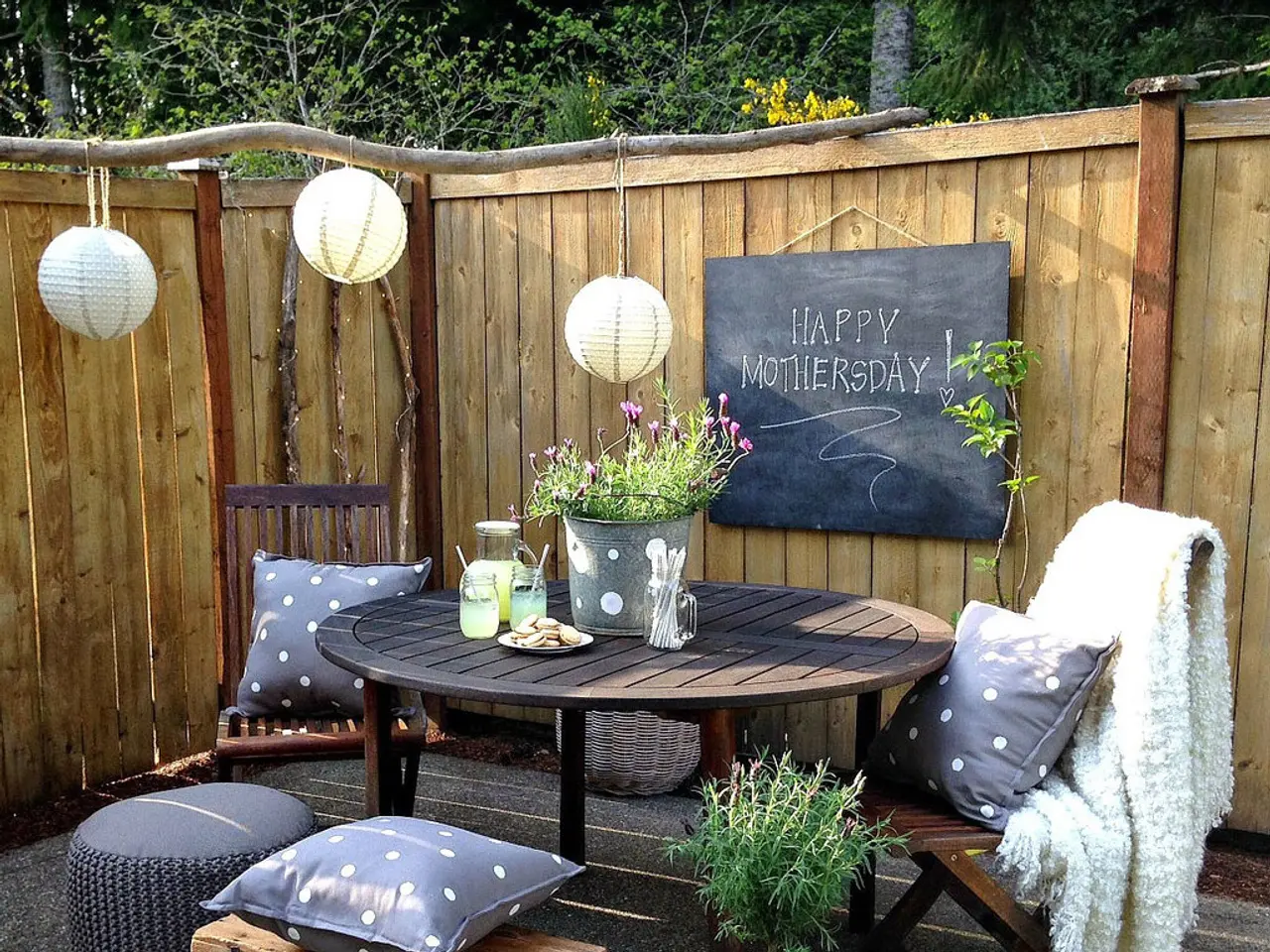 in this picture we can see a balcony which is decorated with table,cushions,lights,here we can also...