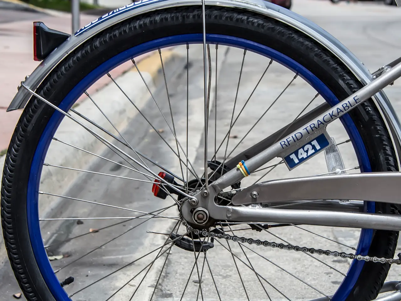 This picture shows a bicycle. It is grey in color and blue color to the rim.