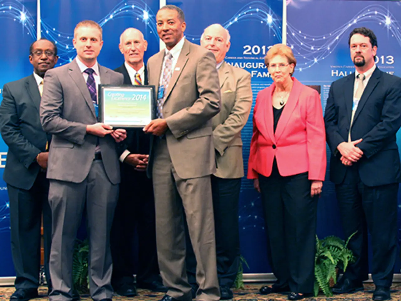 In this image, I can see a group of people standing. Among them two persons are holding a...