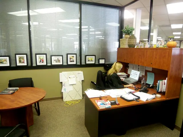 I think this picture is taken in an office. Towards the right, there is a woman working on the...