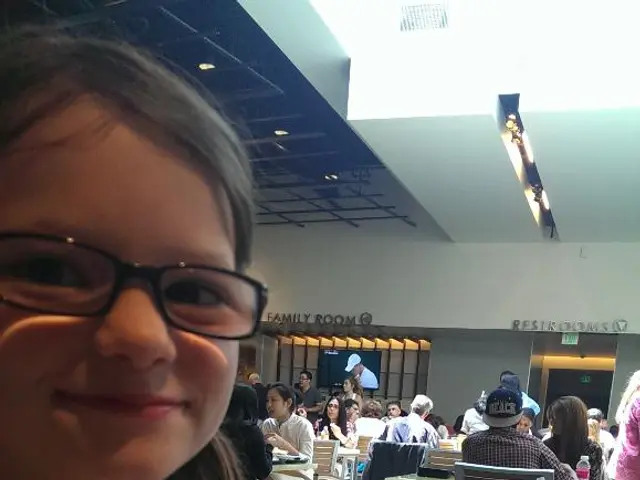 In the image there is a girl on left side holding chopsticks with food in it,in front of her there...