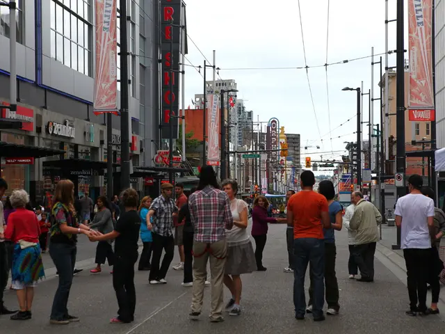 In this image there is a road on which there are few persons who are holding the hands on another...